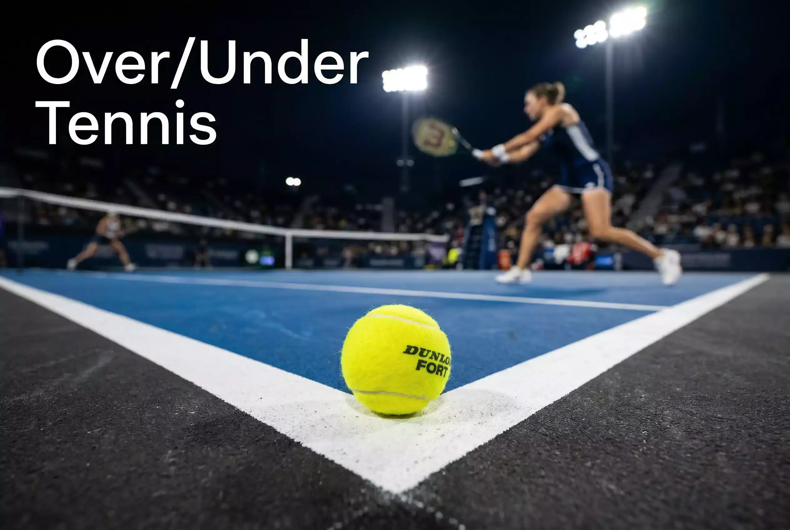Nahaufnahme eines Tennisballs auf der Linie eines Hartplatzes mit unscharfer Spielszene – Over/Under Tenniswetten